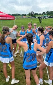 A group of girls in blue jerseys are gathered around.
