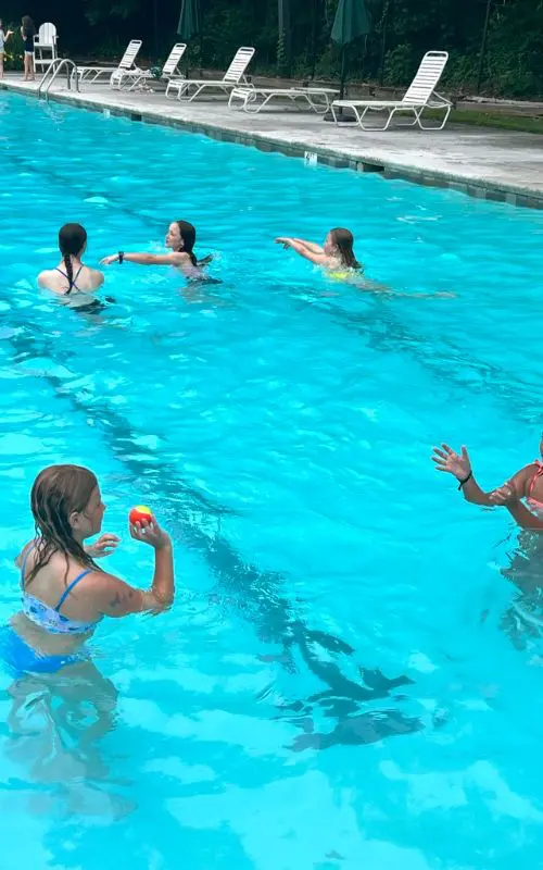A group of people in the pool playing frisbee.