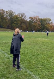 Coach watching girls' lacrosse game.